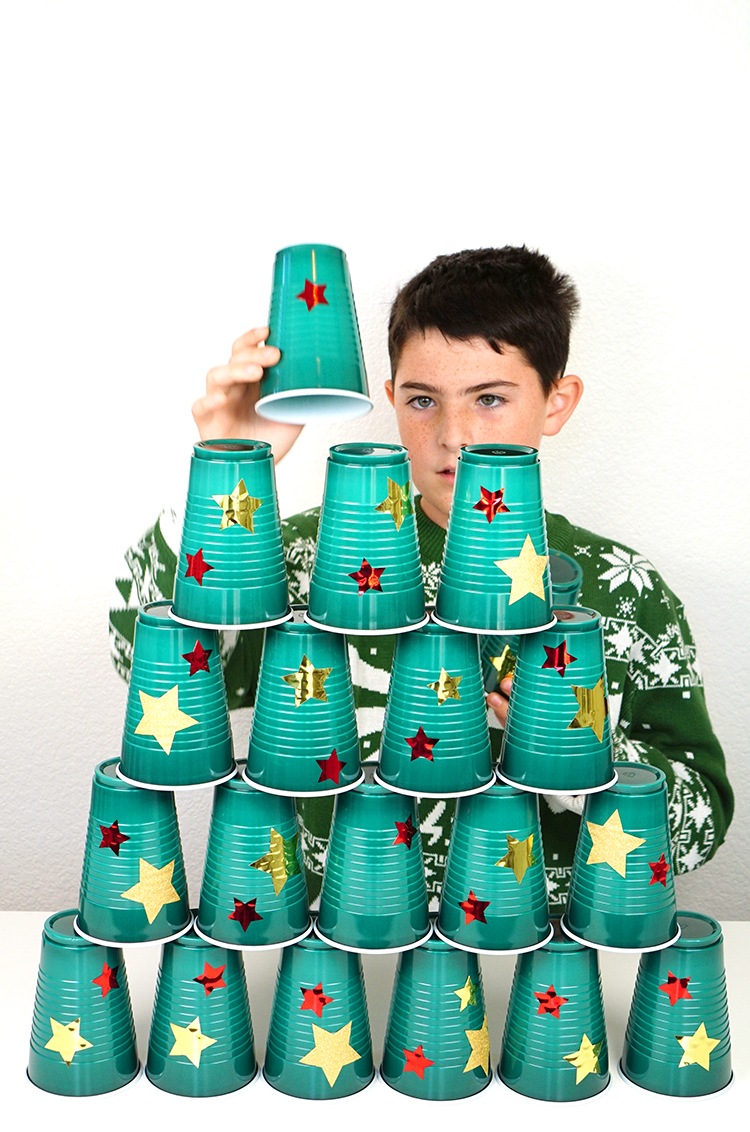 kid playing christmas tree stack minute to win it style party game 