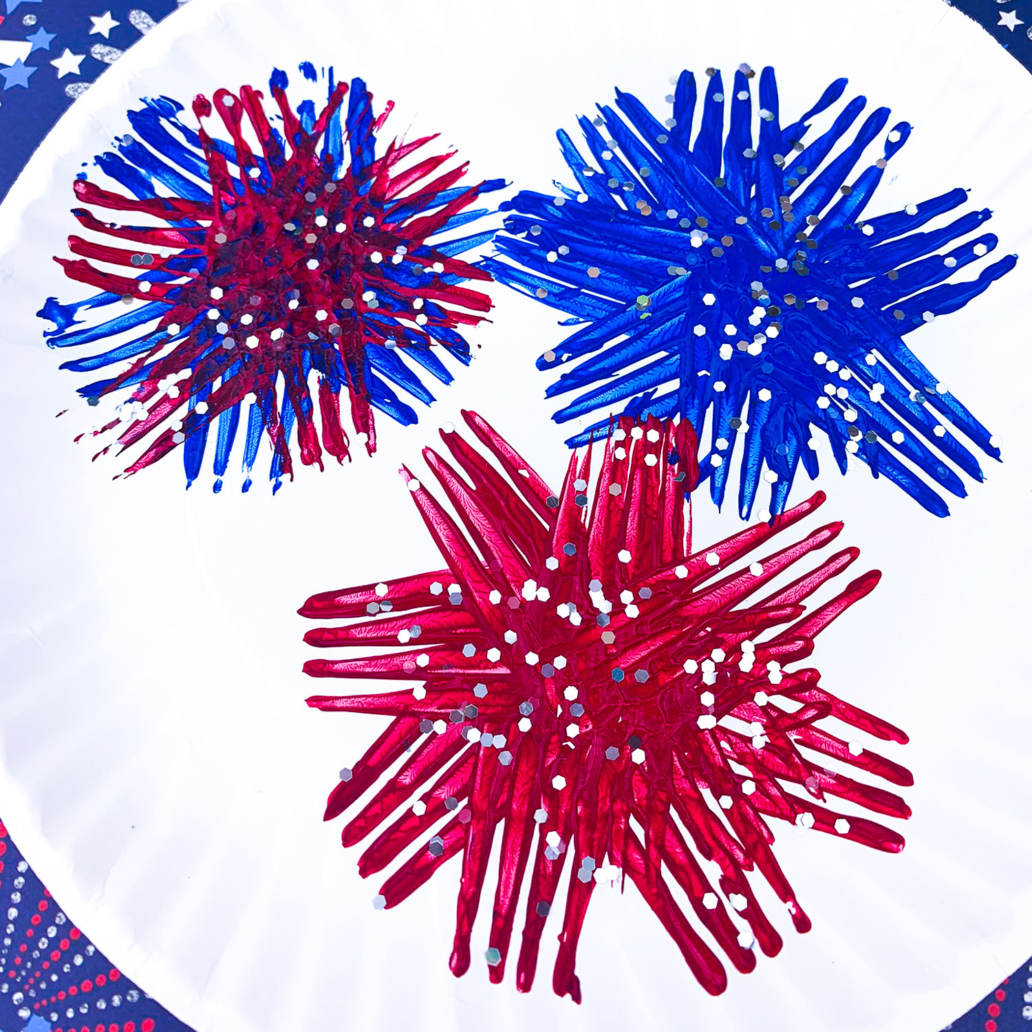 Close up of paper plate fireworks kids craft - fork-painted fireworks on white paper plate