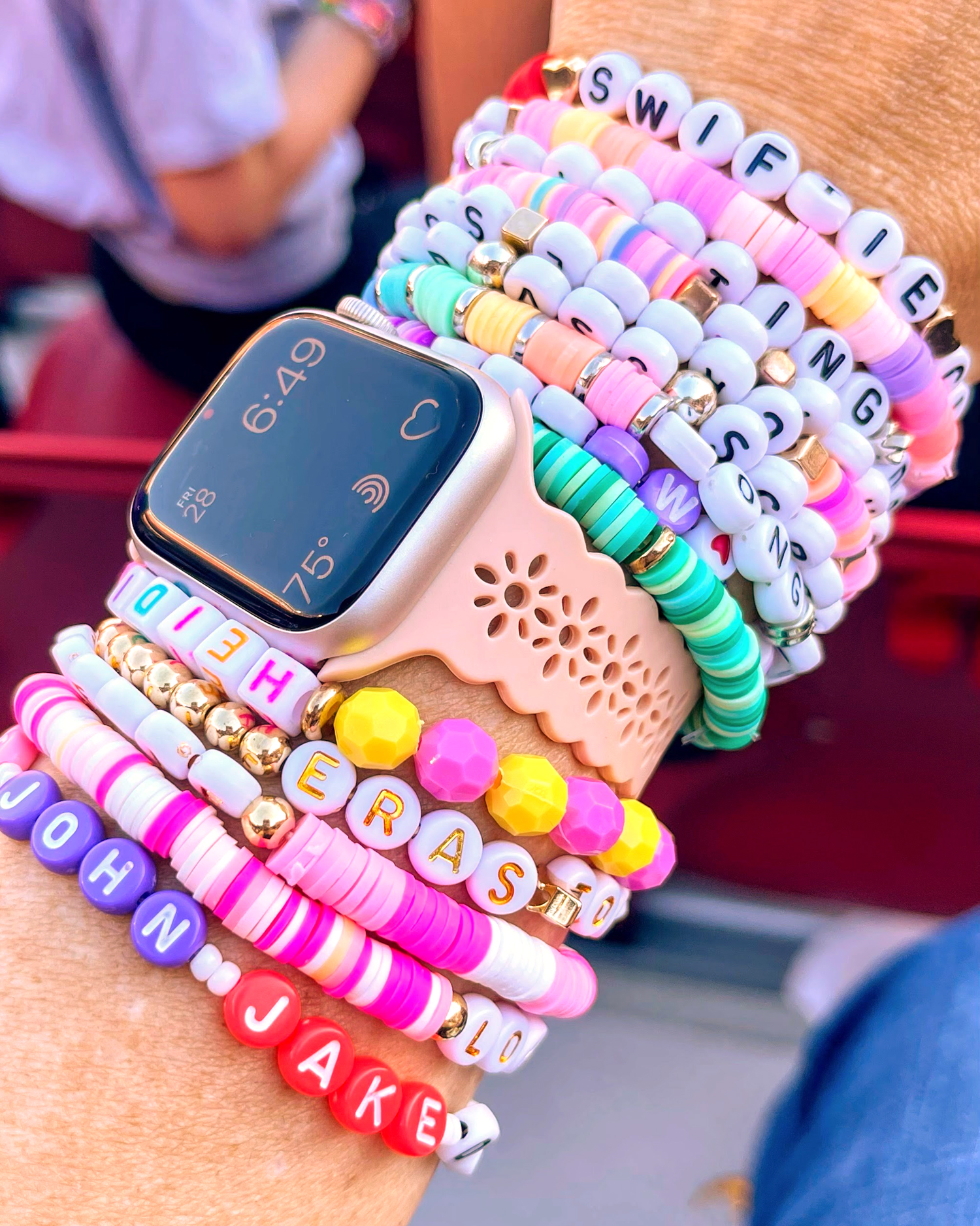 Wrist with watch and arm full of Taylor Swift Eras Tour beaded friendship bracelets