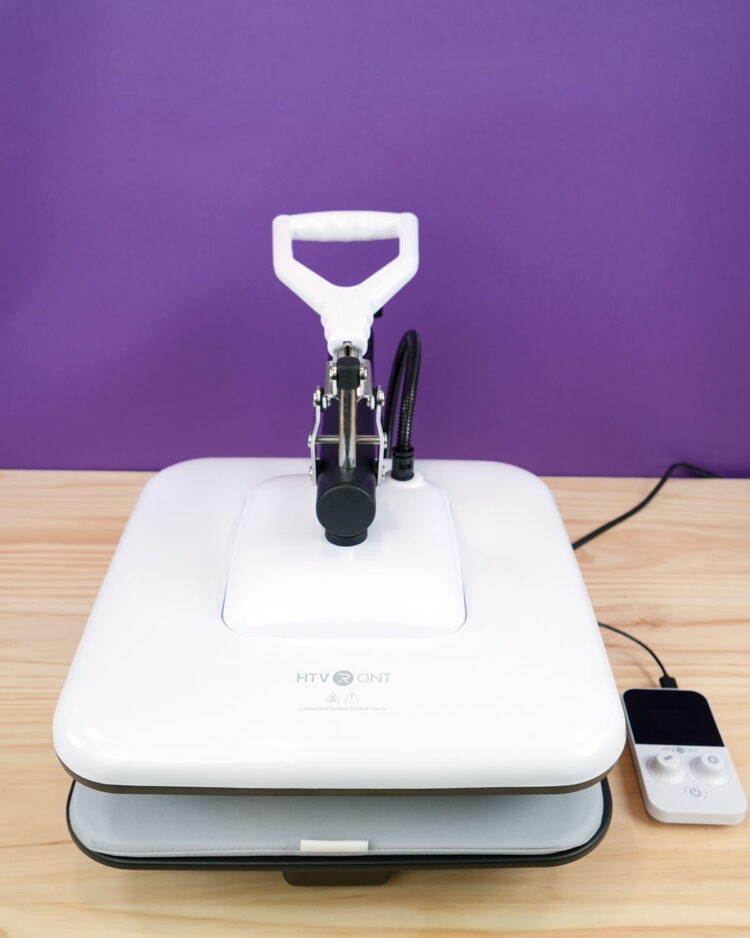 HTVRONT Manual Heat Press Machine on wood table with purple background