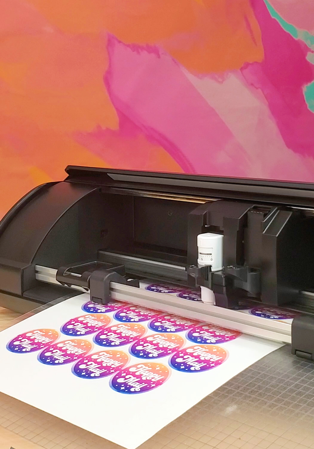 Black Silhouette Cameo 5 cutting machine cutting a sheet of colorful stickers