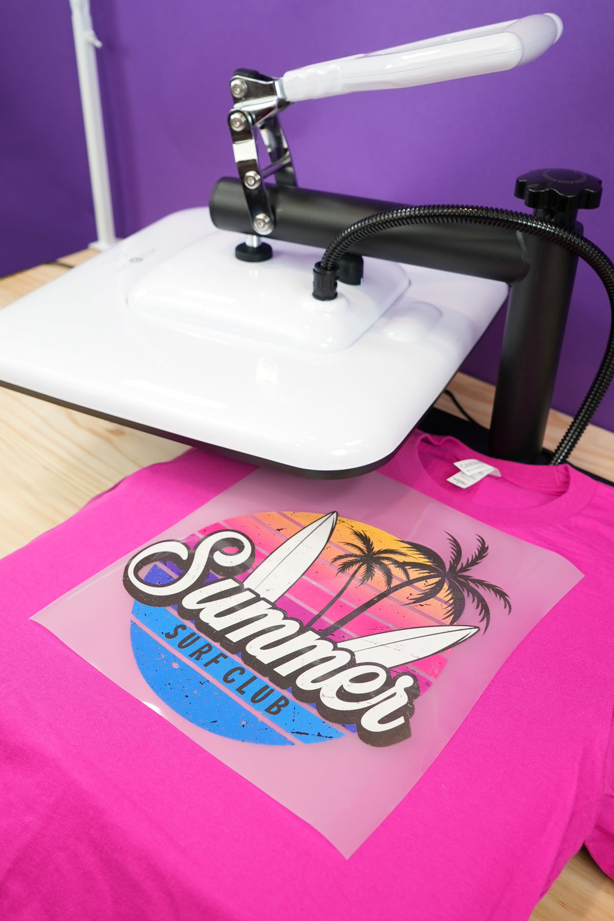 Close up of hot pink shirt on a HTVRONT Manual Heat Press with DTF transfer on top