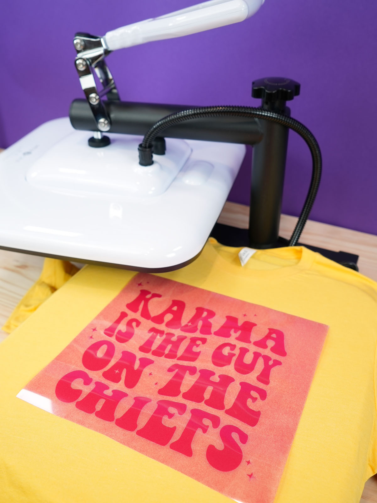 Side angle view of gold "Karma is the Guy on the Chiefs" shirt on the HTVRONT Manual Heat Press Machine