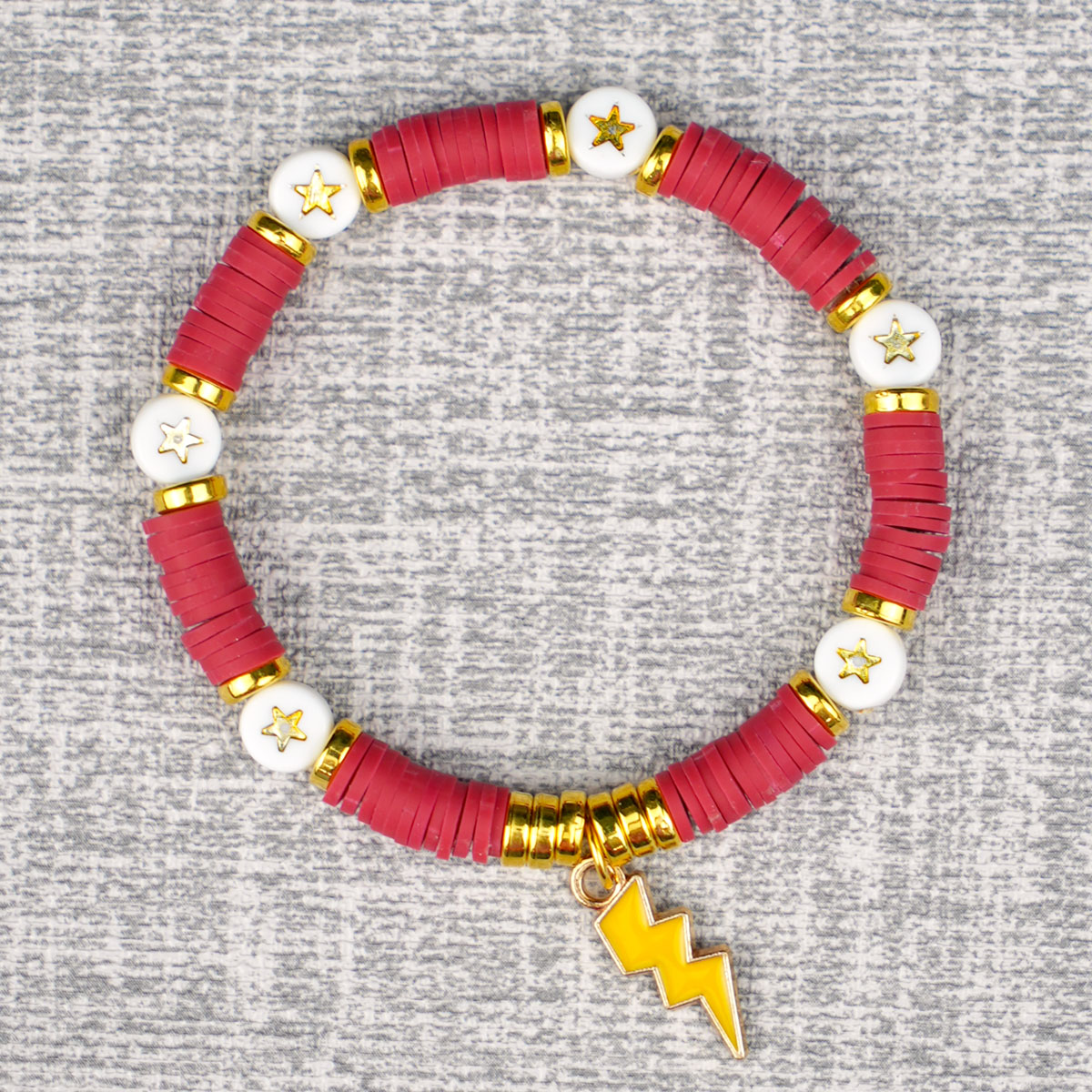 red beaded Gryffindor bracelet with a gold enamel lightning bolt charm on grey background