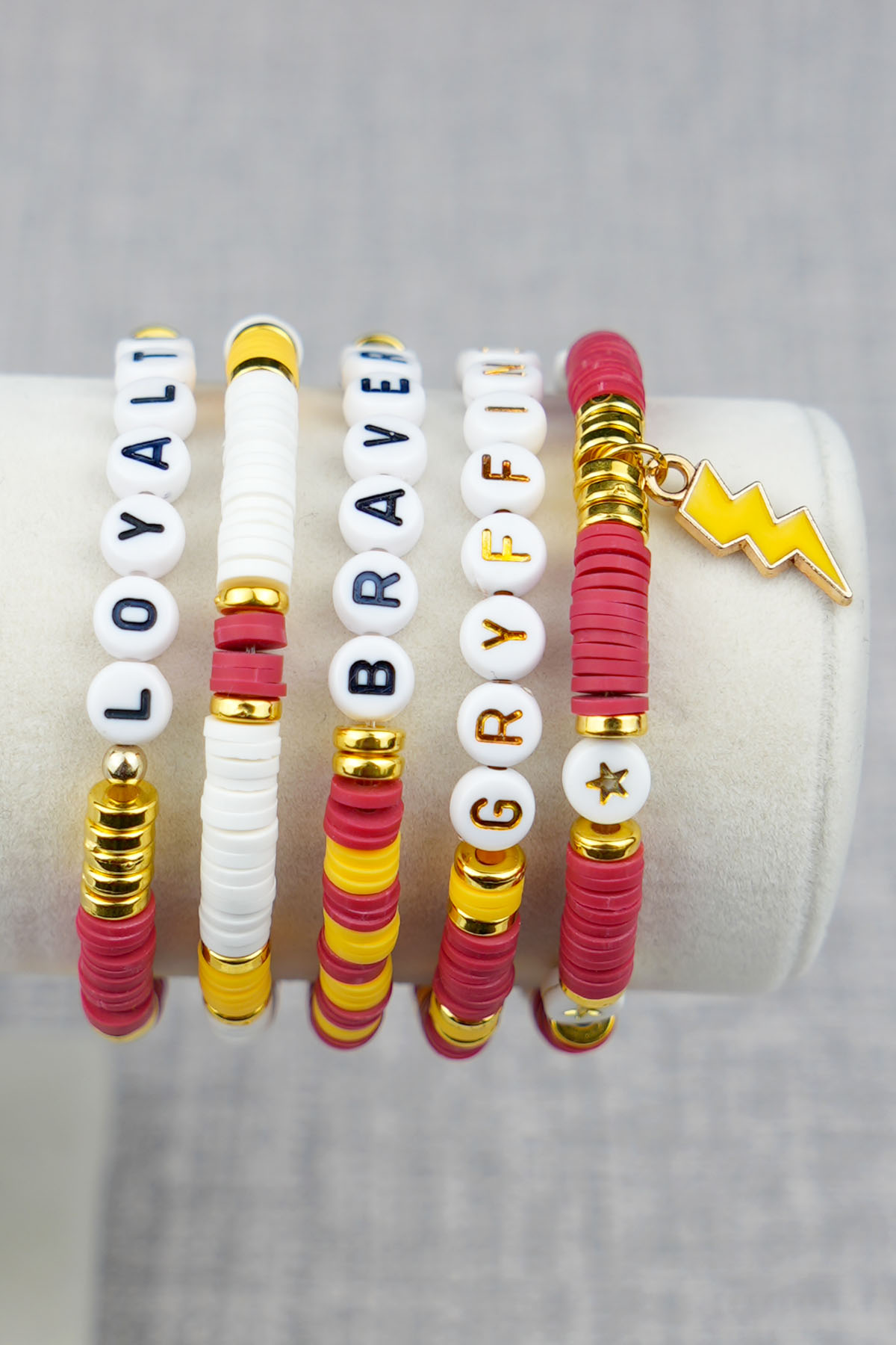 side view of a Harry Potter Gryffindor House Bracelet Set on a bracelet stand